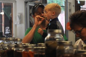 Ann Arbor residents Wade De Vries, 3 years old, and his father Greg De Vries try pickles at The Eighth Annual Pickle Contest and Public Tasting at Downtown Home & Garden on Saturday. Sinduja Kilaru/Daily  